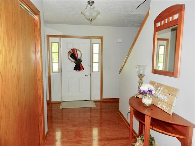 foyer with a textured ceiling and dark hardwood / wood-style floors