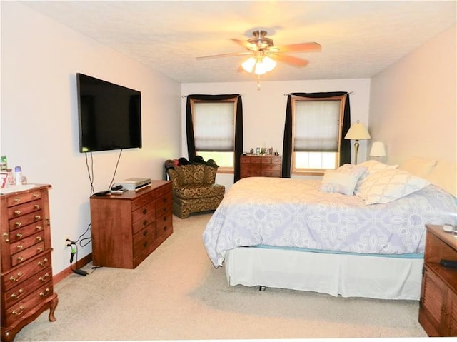 bedroom featuring light colored carpet and ceiling fan