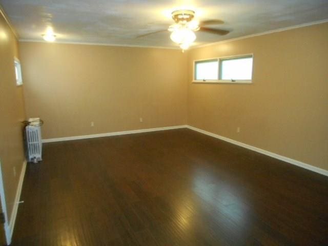 empty room featuring ornamental molding, ceiling fan, and dark hardwood / wood-style flooring