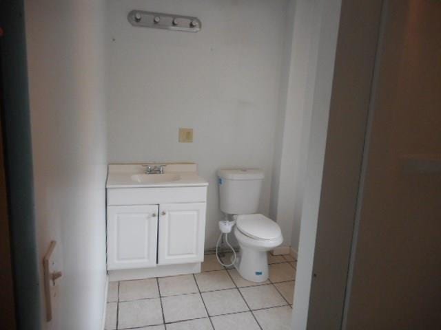 bathroom featuring toilet, tile floors, and vanity