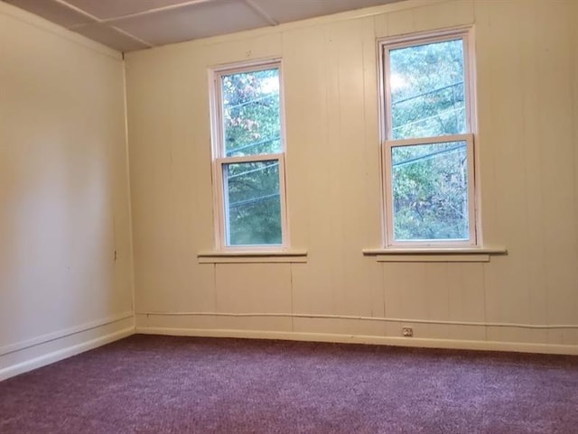 spare room featuring dark colored carpet