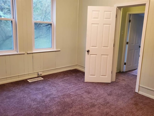 empty room featuring dark carpet