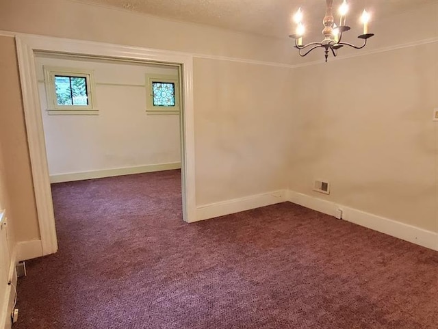 spare room with dark colored carpet and a chandelier