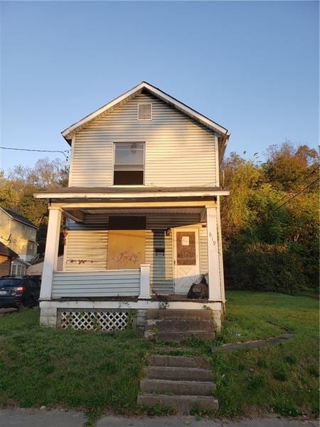 view of front of property featuring covered porch and a front lawn