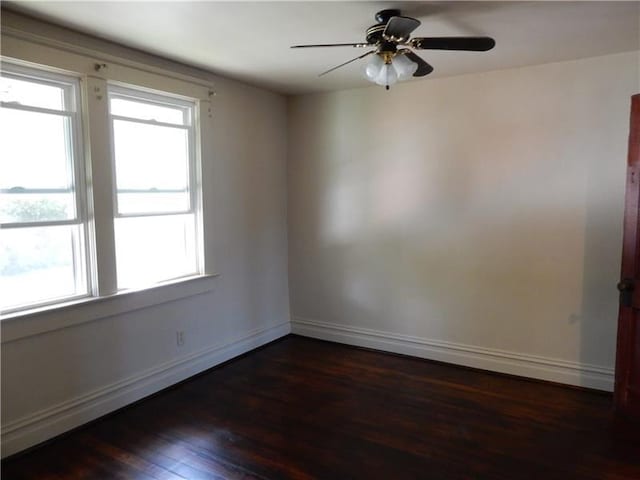 empty room with dark hardwood / wood-style floors and ceiling fan