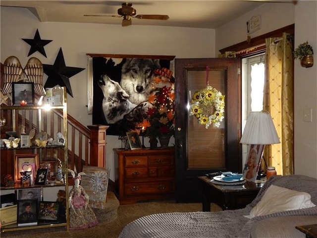 sitting room featuring dark carpet and ceiling fan