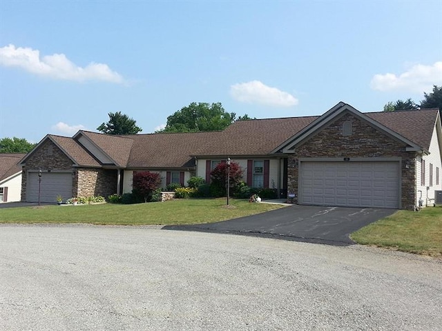 ranch-style house with a front yard, a garage, and central AC unit