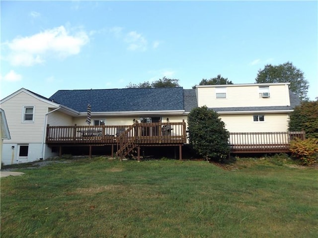 rear view of house featuring a wooden deck and a yard