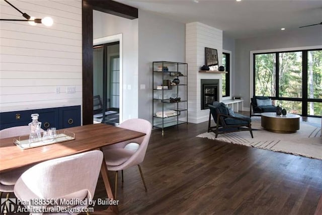 office space with brick wall, dark hardwood / wood-style floors, and a large fireplace