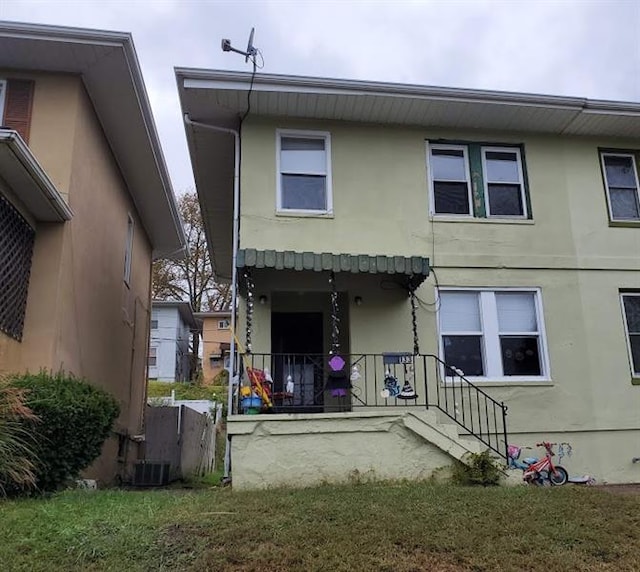 back of property with central air condition unit and a lawn