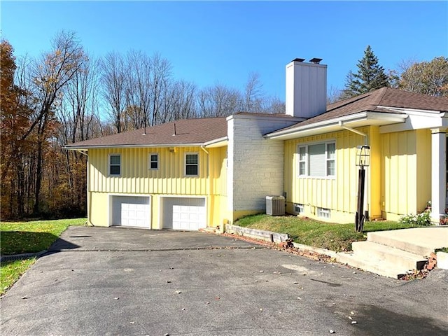 view of front of property with central air condition unit and a garage