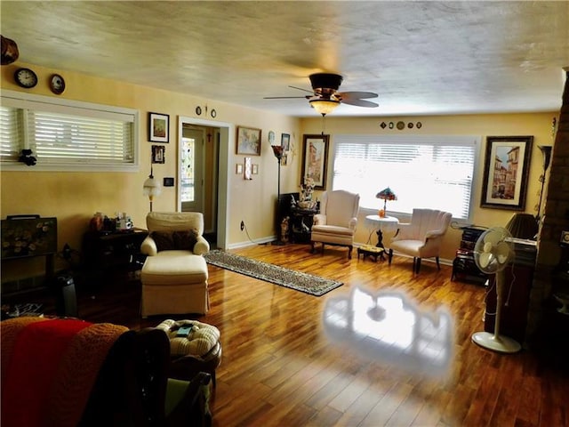 living room featuring wood-type flooring and ceiling fan