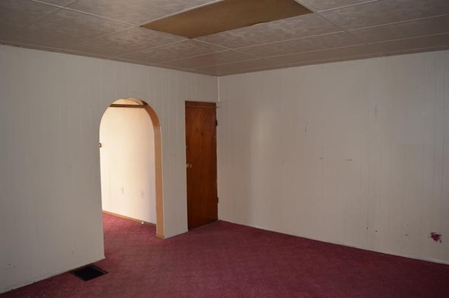 empty room with dark colored carpet