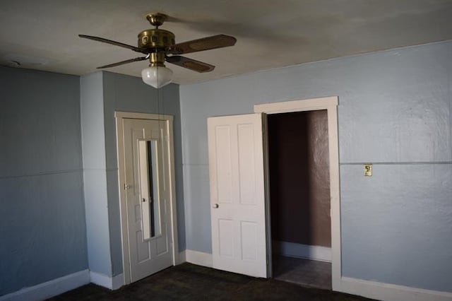 unfurnished bedroom featuring dark carpet and ceiling fan