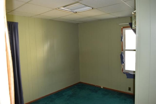 carpeted spare room featuring a paneled ceiling