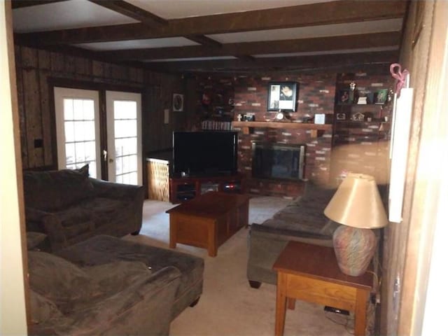 living room featuring light colored carpet, wooden walls, french doors, and a fireplace