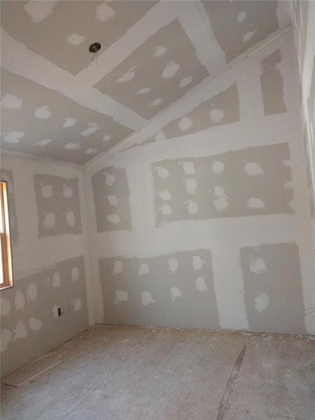 spare room featuring lofted ceiling