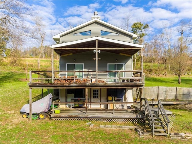 rear view of house featuring a wooden deck and a yard