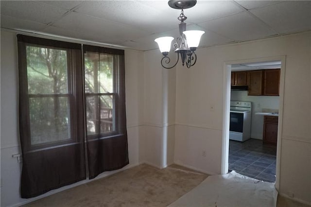 unfurnished dining area featuring light tile floors, a notable chandelier, and a drop ceiling