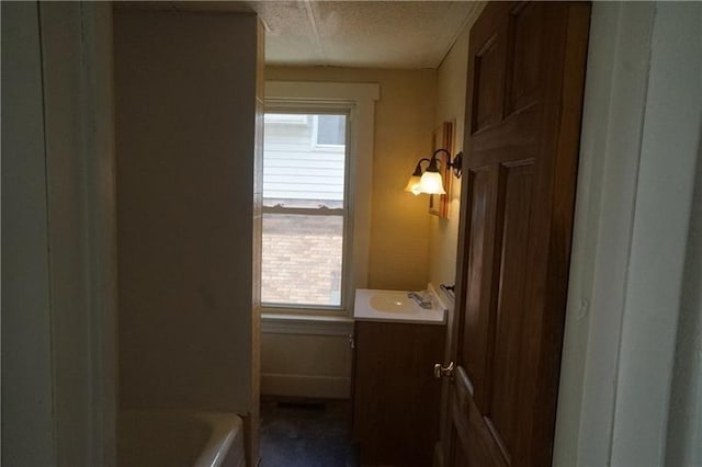 bathroom with a textured ceiling, vanity, and shower / bath combination