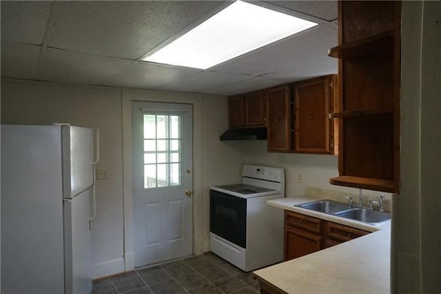 kitchen featuring a paneled ceiling, dark tile floors, white appliances, and sink