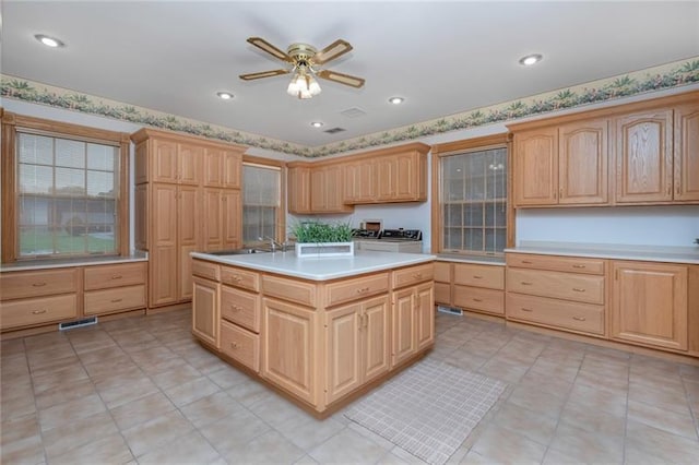 kitchen featuring ceiling fan, light brown cabinets, sink, and light tile floors