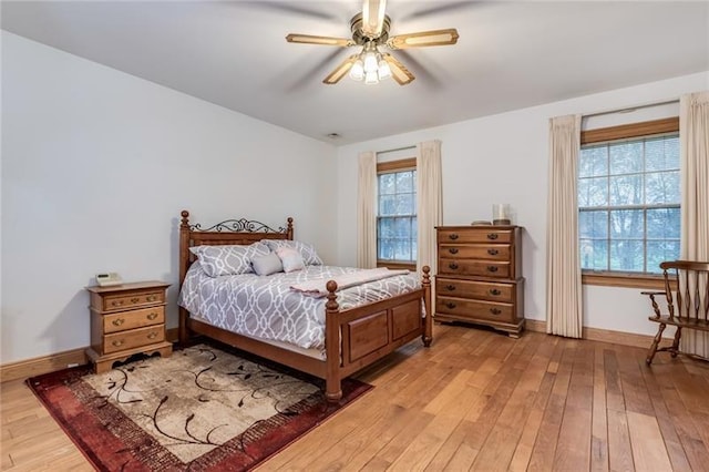 bedroom with light hardwood / wood-style floors, ceiling fan, and multiple windows