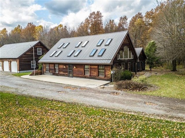 log home featuring covered porch and a garage