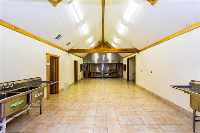 interior space featuring beamed ceiling, high vaulted ceiling, and light tile floors