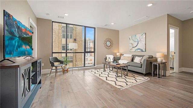 living area featuring floor to ceiling windows and light wood-type flooring