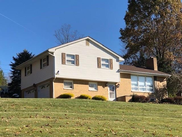 split level home with a front lawn and a garage