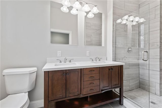 bathroom featuring double sink vanity, tile floors, toilet, and a shower with shower door