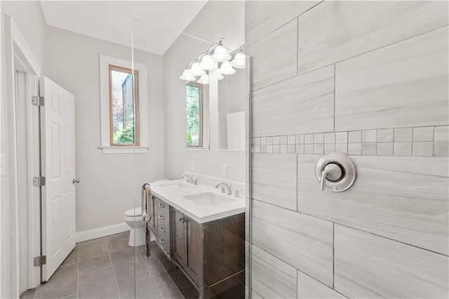 bathroom with dual sinks, tile floors, toilet, and vanity with extensive cabinet space