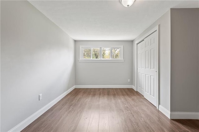 unfurnished bedroom with dark hardwood / wood-style flooring and a closet