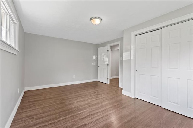 unfurnished bedroom featuring dark hardwood / wood-style flooring and a closet