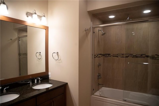 bathroom with dual vanity and combined bath / shower with glass door