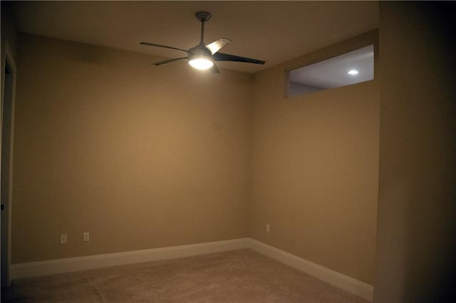 carpeted spare room featuring ceiling fan