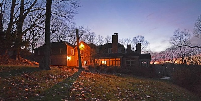 view of back house at dusk