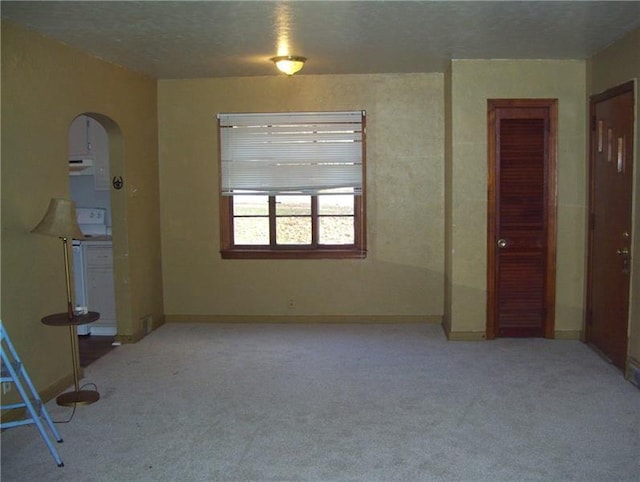 empty room featuring light colored carpet and a textured ceiling