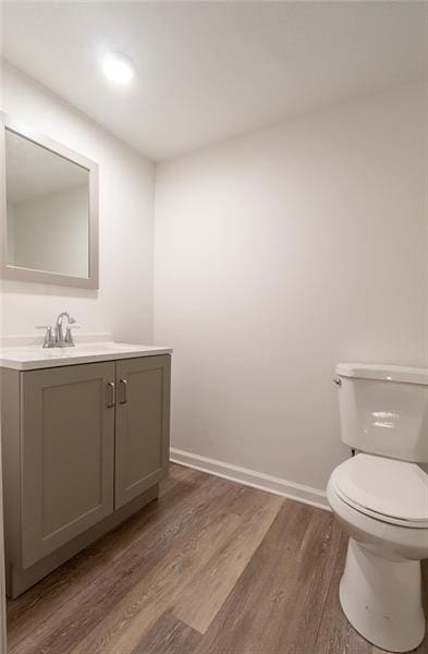 bathroom featuring toilet, hardwood / wood-style floors, and vanity