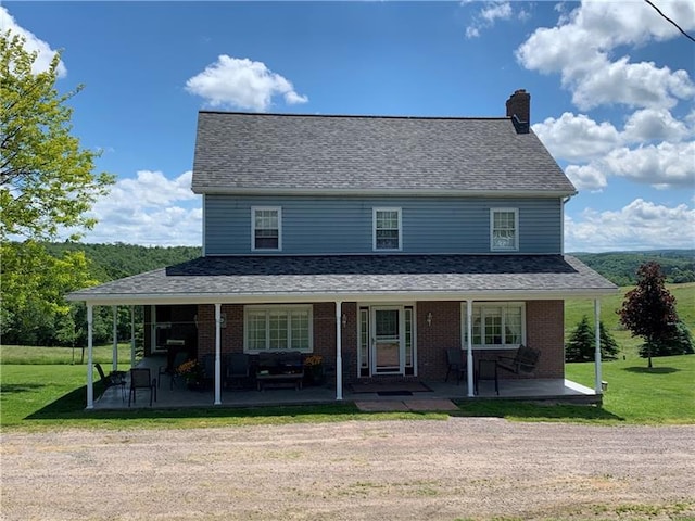 farmhouse-style home with a front yard and covered porch