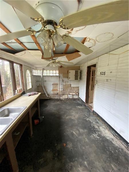 interior space featuring concrete flooring and ceiling fan