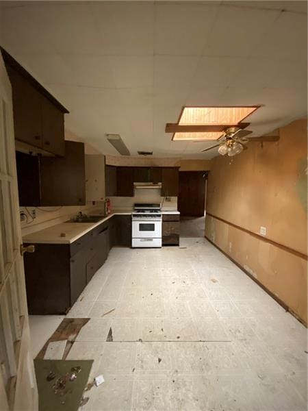 kitchen featuring ceiling fan, dark brown cabinets, extractor fan, and stove