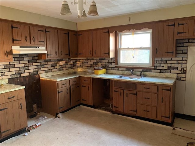 kitchen featuring pendant lighting, sink, and backsplash