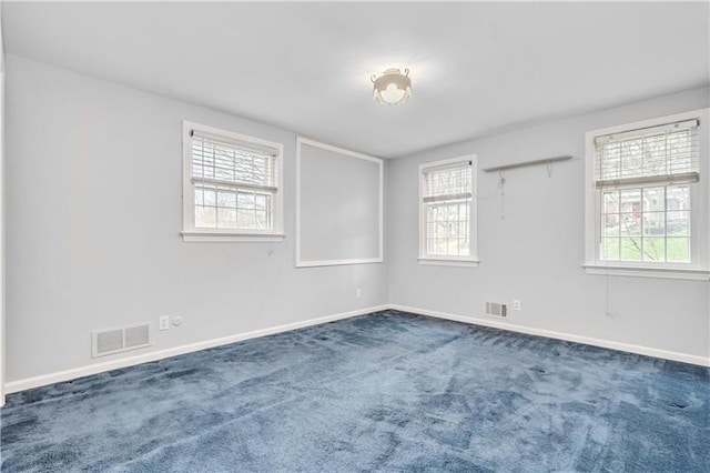 carpeted spare room featuring a healthy amount of sunlight