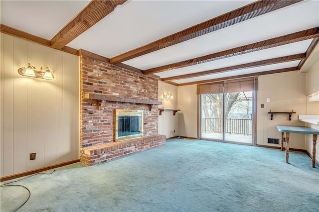 unfurnished living room featuring light carpet, a fireplace, brick wall, and beamed ceiling