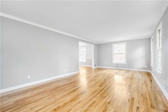 spare room with crown molding and light wood-type flooring