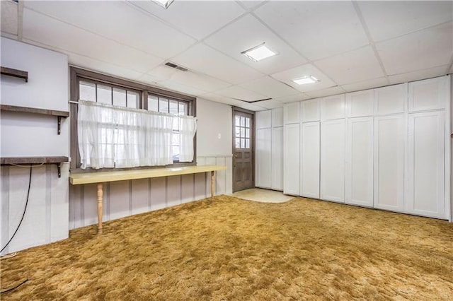 carpeted empty room with a paneled ceiling