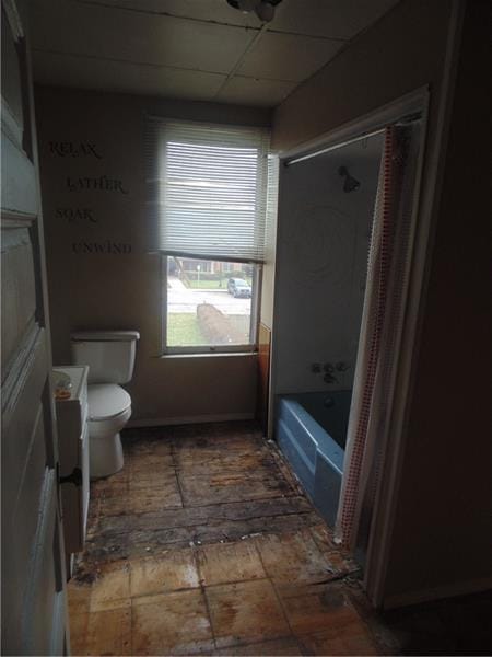 bathroom featuring tub / shower combination, a paneled ceiling, and toilet