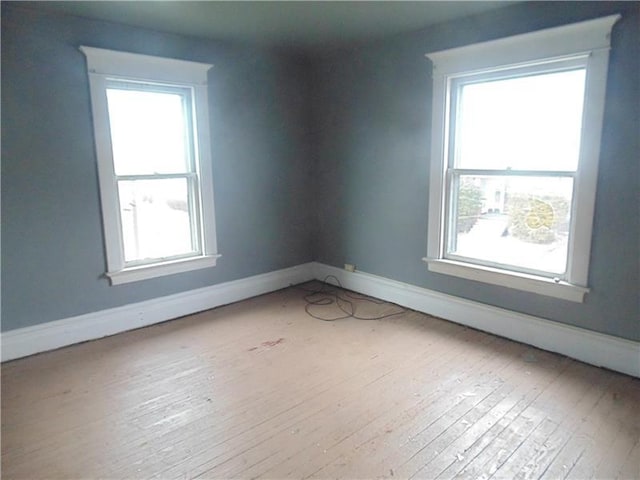 spare room with light hardwood / wood-style flooring and plenty of natural light